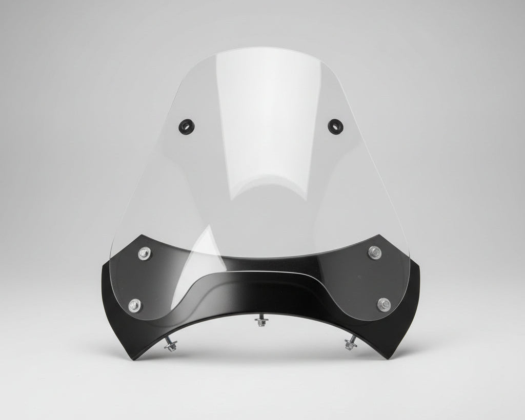 Clear motorcycle windshield with black bracket on a wooden surface