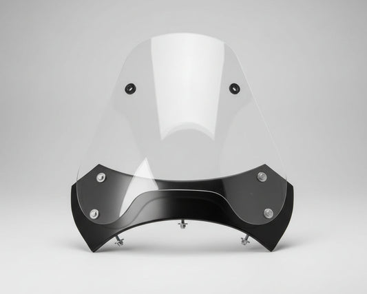 Clear motorcycle windshield with black bracket on a wooden surface